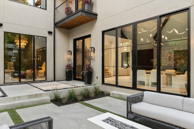 view of patio with visible vents, an outdoor living space with a fire pit, and a balcony