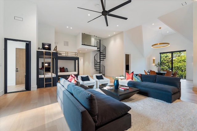 living room with visible vents, wood finished floors, stairs, a high ceiling, and recessed lighting