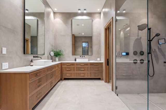 bathroom featuring double vanity, tile walls, a walk in shower, and a sink