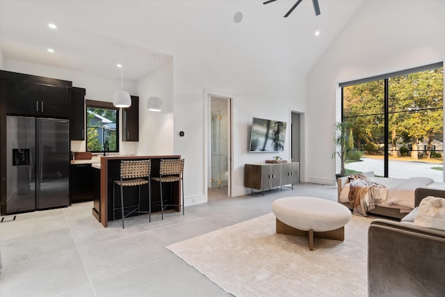 living room with baseboards, high vaulted ceiling, ceiling fan, and recessed lighting