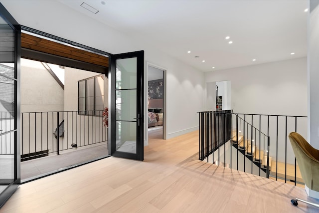 hall featuring recessed lighting, baseboards, wood finished floors, and an upstairs landing