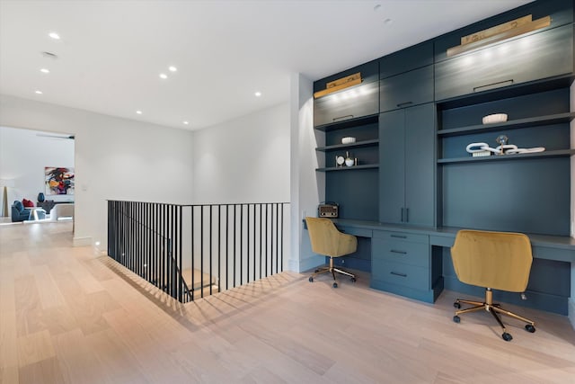 office space with built in desk, recessed lighting, and light wood-style flooring