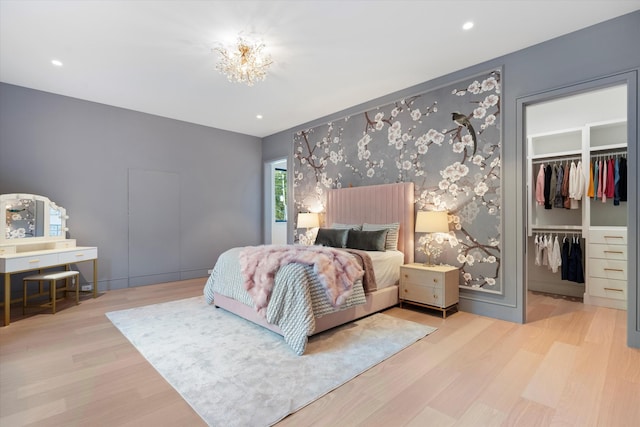 bedroom with a notable chandelier, recessed lighting, a closet, a spacious closet, and wood finished floors