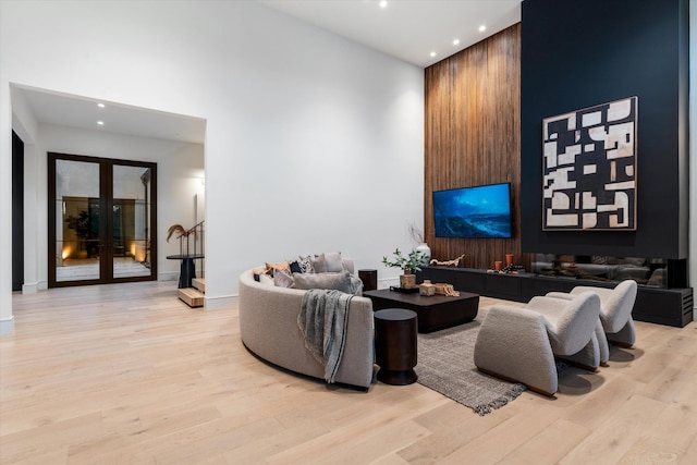 living area featuring light wood-type flooring, a high ceiling, stairway, and recessed lighting