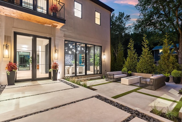 exterior space with a patio area, stucco siding, an outdoor hangout area, and french doors