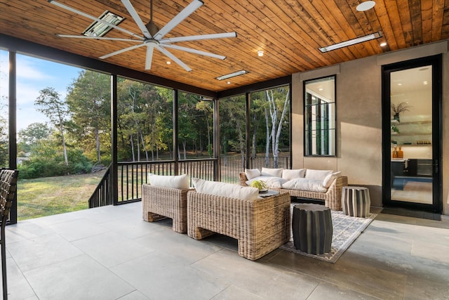 sunroom featuring wood ceiling and a ceiling fan