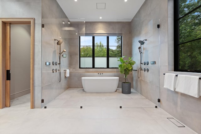 bathroom with a stall shower, a freestanding tub, and tile walls