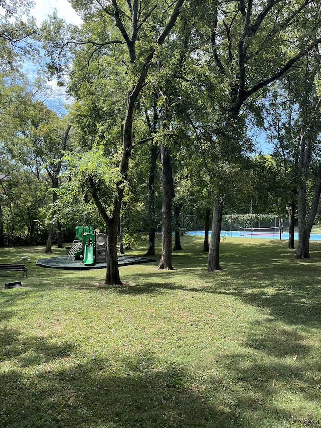 view of yard featuring tennis court, a water view, and a playground