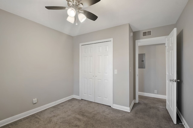 unfurnished bedroom featuring ceiling fan, a closet, and dark colored carpet