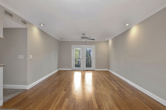 unfurnished room featuring hardwood / wood-style floors, ceiling fan, crown molding, and french doors