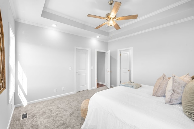 bedroom with ceiling fan, a raised ceiling, crown molding, and carpet flooring