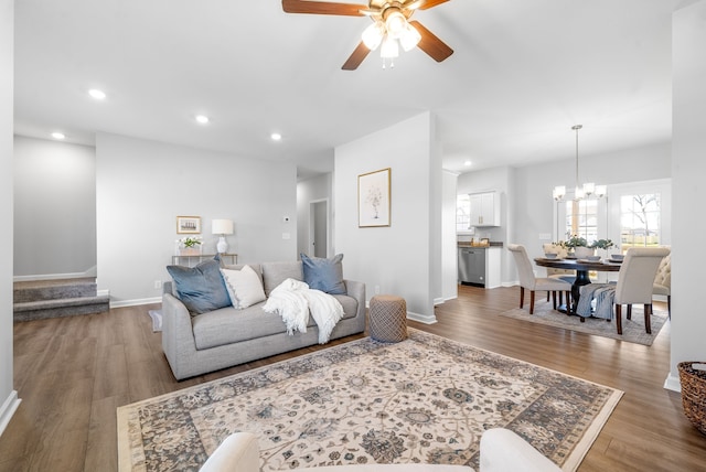 living room featuring ceiling fan with notable chandelier and wood-type flooring