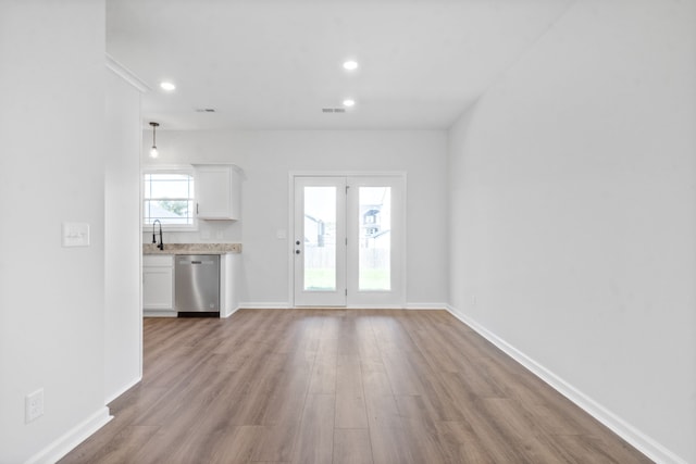 unfurnished living room with sink and light wood-type flooring