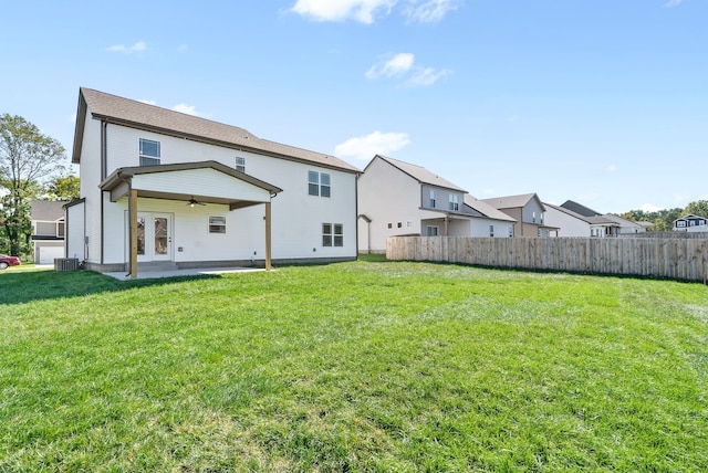 rear view of property featuring a yard, central AC, ceiling fan, and a patio