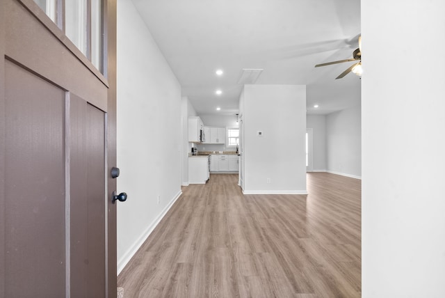 unfurnished living room with light wood-type flooring and ceiling fan