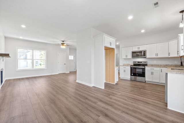 kitchen with ceiling fan, hardwood / wood-style floors, sink, appliances with stainless steel finishes, and white cabinetry