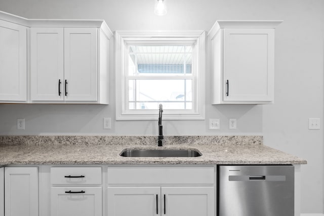 kitchen with light stone countertops, sink, white cabinetry, and stainless steel dishwasher