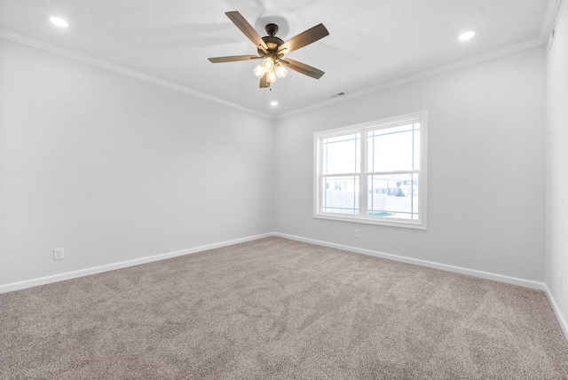 empty room with ceiling fan, crown molding, and carpet