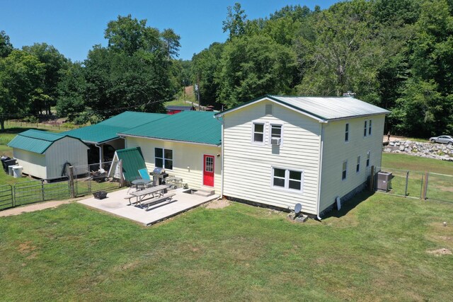 rear view of house featuring a yard, cooling unit, and a patio area