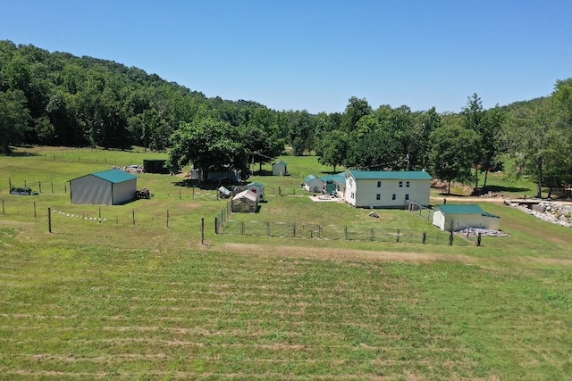 surrounding community featuring a rural view, a lawn, and an outdoor structure