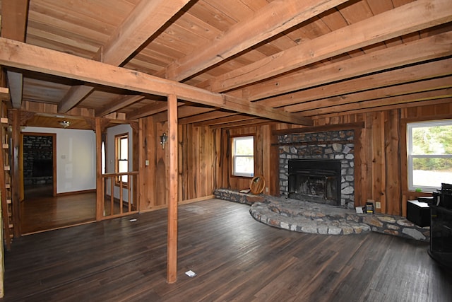 unfurnished living room with wooden ceiling, beam ceiling, dark hardwood / wood-style flooring, and a wealth of natural light