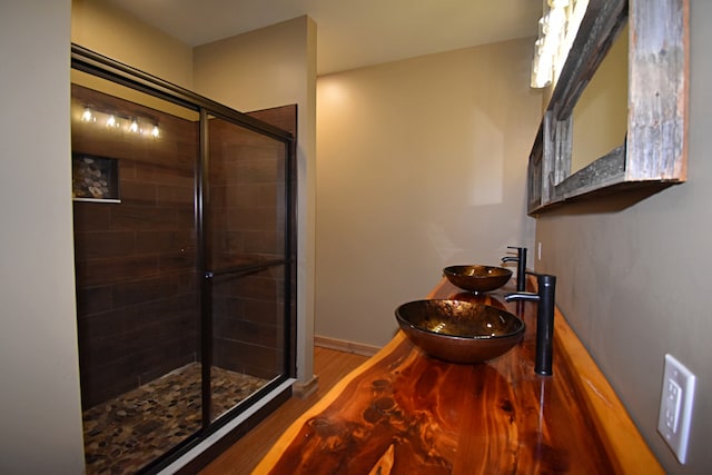 bathroom featuring a shower with door, hardwood / wood-style floors, and sink