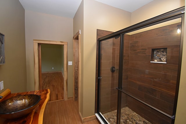 bathroom featuring a shower with door and hardwood / wood-style floors