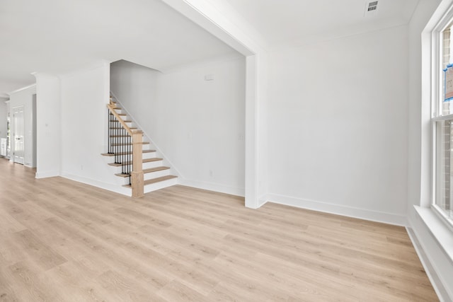 interior space with ornamental molding and light wood-type flooring