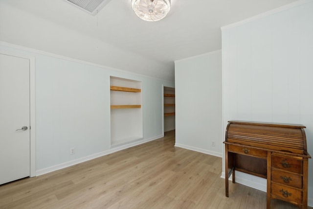 interior space featuring light wood-style floors, ornamental molding, and baseboards