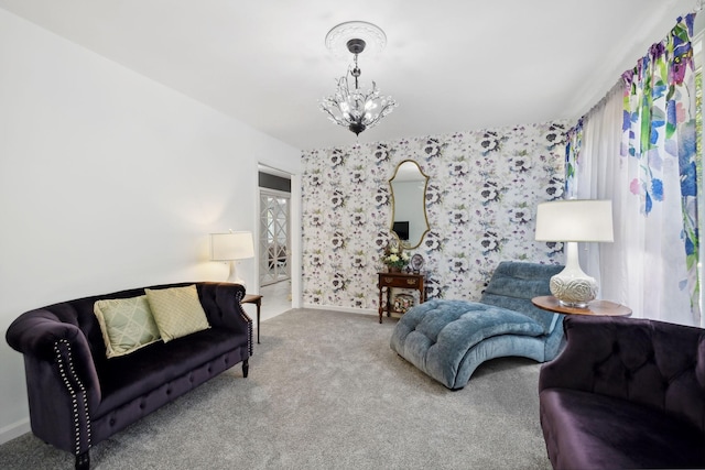 carpeted living area featuring baseboards and an inviting chandelier