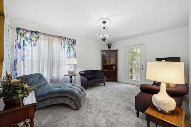 bedroom featuring light carpet, access to outside, and a chandelier