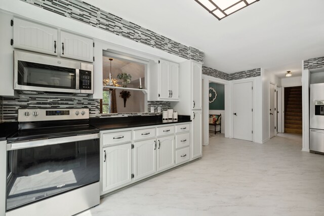 kitchen featuring white cabinetry, stainless steel appliances, and tasteful backsplash