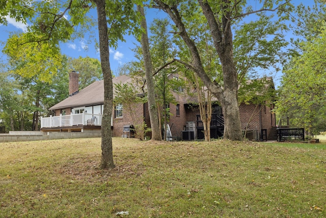 view of front facade featuring central air condition unit, a wooden deck, and a front yard