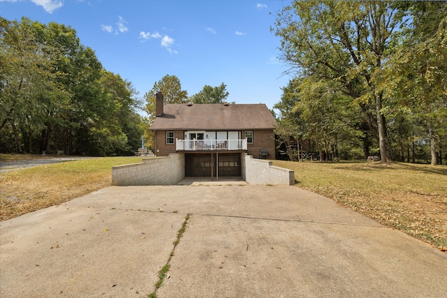 view of front of house with a balcony and a front yard