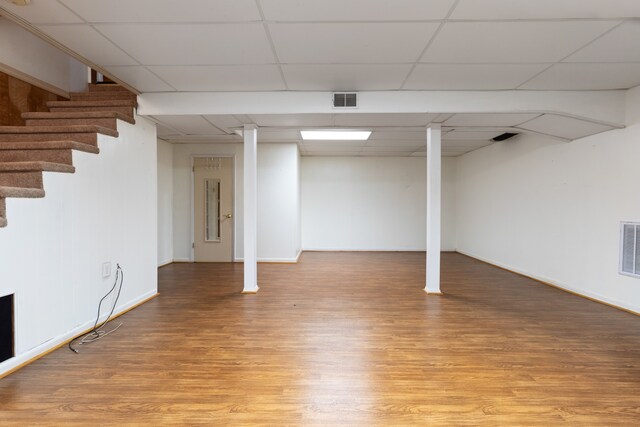 basement with light hardwood / wood-style flooring and a drop ceiling