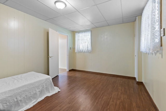 bedroom featuring a paneled ceiling and dark hardwood / wood-style floors