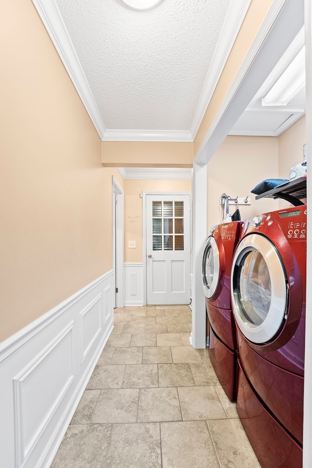 laundry area with ornamental molding, a textured ceiling, and independent washer and dryer