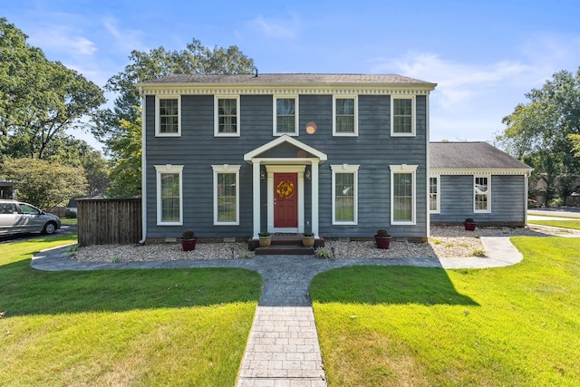 colonial-style house featuring a front lawn