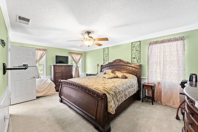 carpeted bedroom featuring ornamental molding, a textured ceiling, and ceiling fan