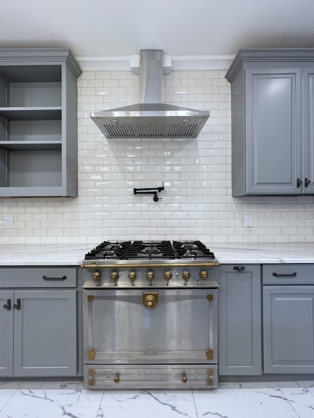 kitchen with backsplash, gray cabinetry, high end range, and wall chimney exhaust hood