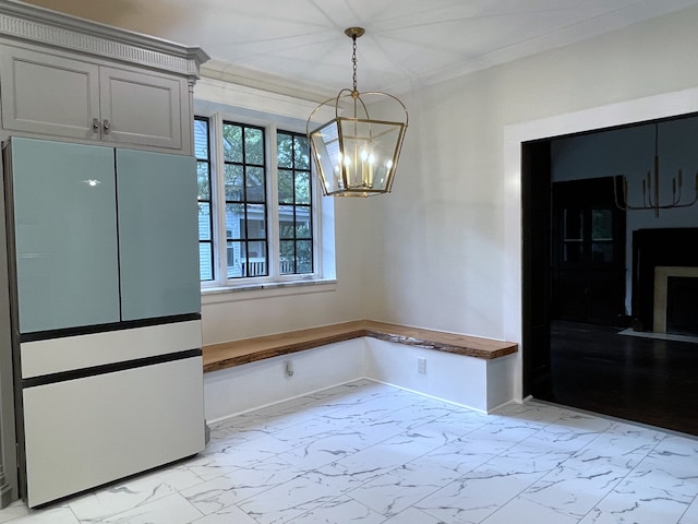 unfurnished dining area with an inviting chandelier and ornamental molding