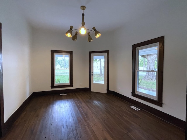 401 College St, Petersburg, TN 37144 - empty room featuring a chandelier, dark wood-type flooring, visible vents, and baseboards