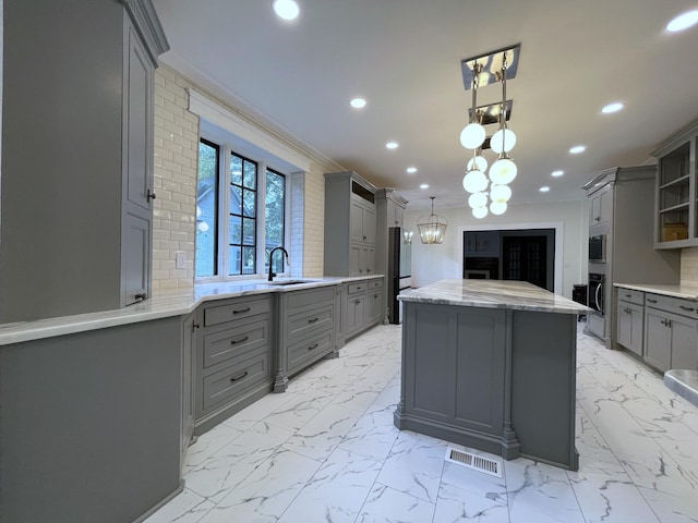 401 College St, Petersburg, TN 37144 - kitchen featuring ornamental molding, marble finish floor, a sink, and gray cabinetry
