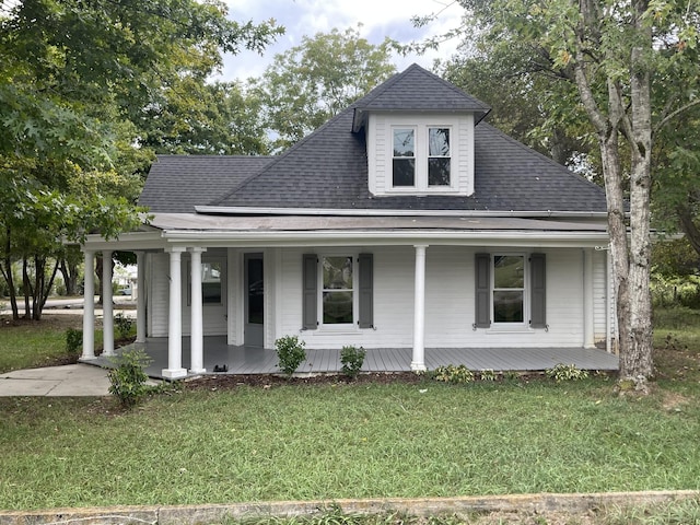 view of front facade with a shingled roof, covered porch, and a front lawn