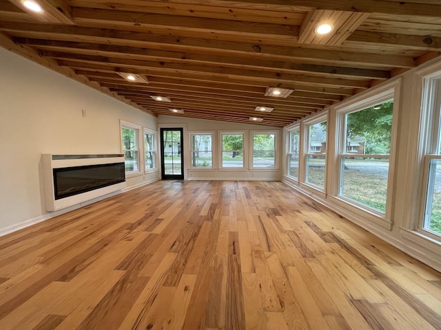 401 College St, Petersburg, TN 37144 - unfurnished living room featuring vaulted ceiling, a glass covered fireplace, light wood-style flooring, and baseboards