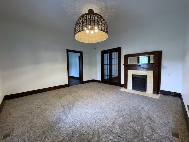 unfurnished living room featuring carpet flooring and an inviting chandelier