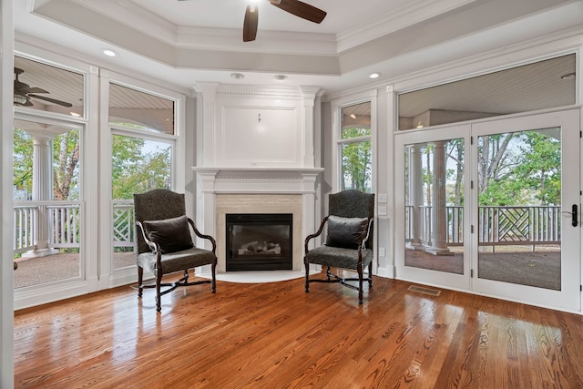 sitting room with ceiling fan, ornamental molding, and wood-type flooring