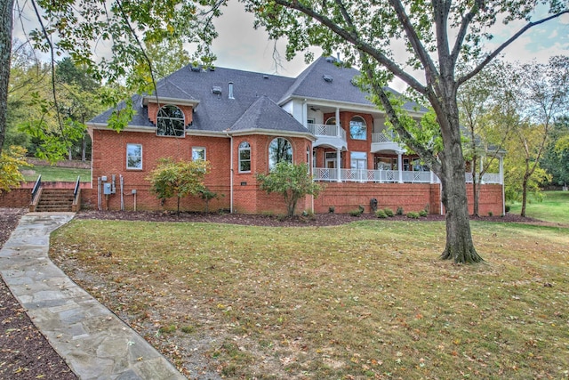 view of front of property featuring a balcony and a front lawn