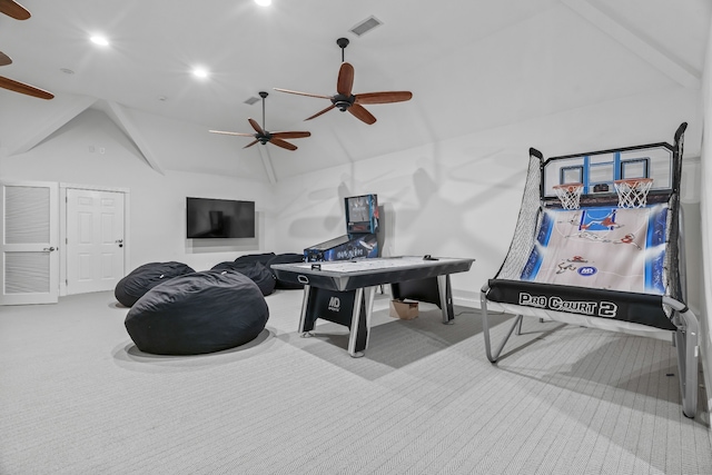 rec room with ceiling fan, light carpet, and vaulted ceiling with beams