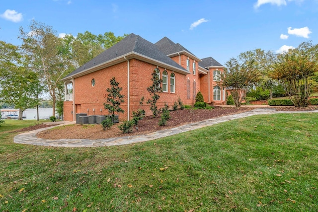 view of property exterior with a yard and central AC